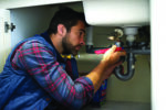 Shot of a plumber fixing a pipe